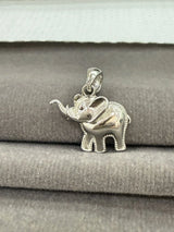 Silver elephant pendant on a gray fabric background