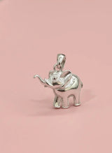 Silver elephant pendant on a pink background