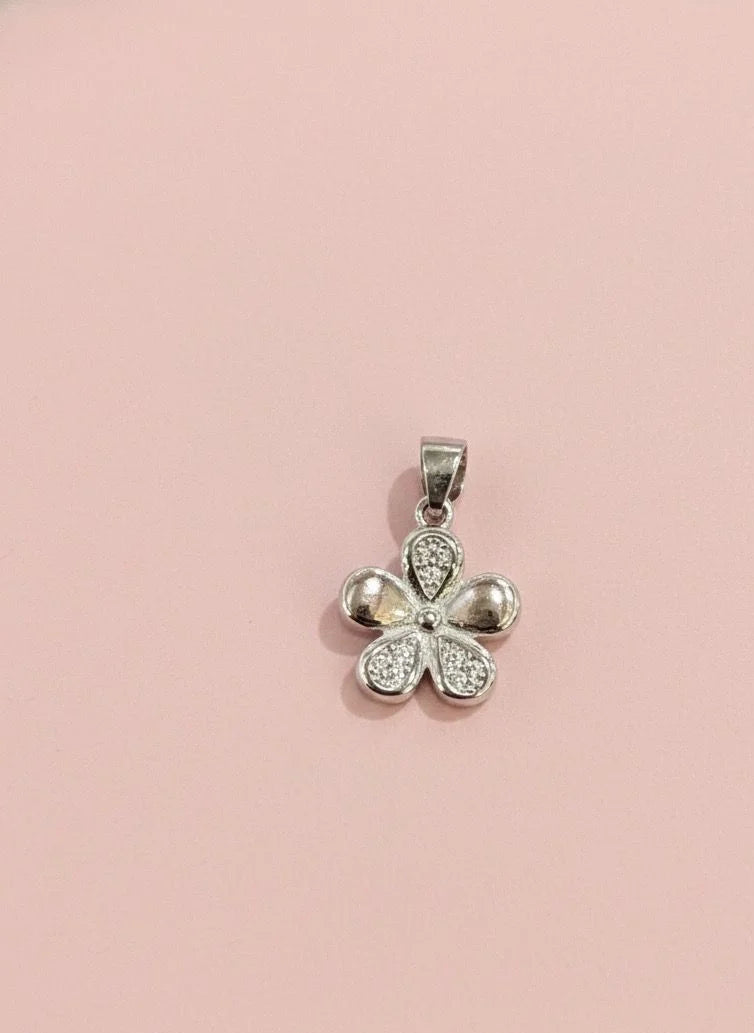 Silver four-leaf clover pendant on a pink background