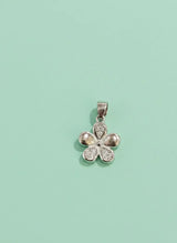 Silver flower-shaped pendant on a light green background