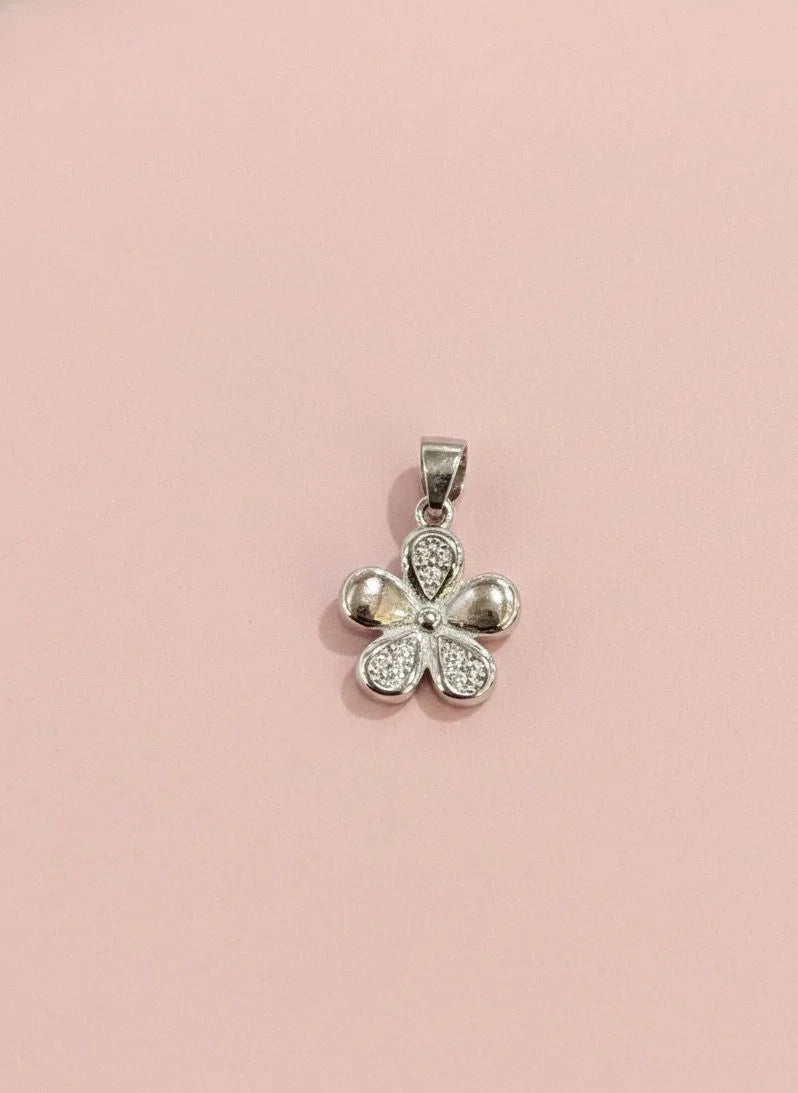 Silver four-leaf clover pendant on a pink background