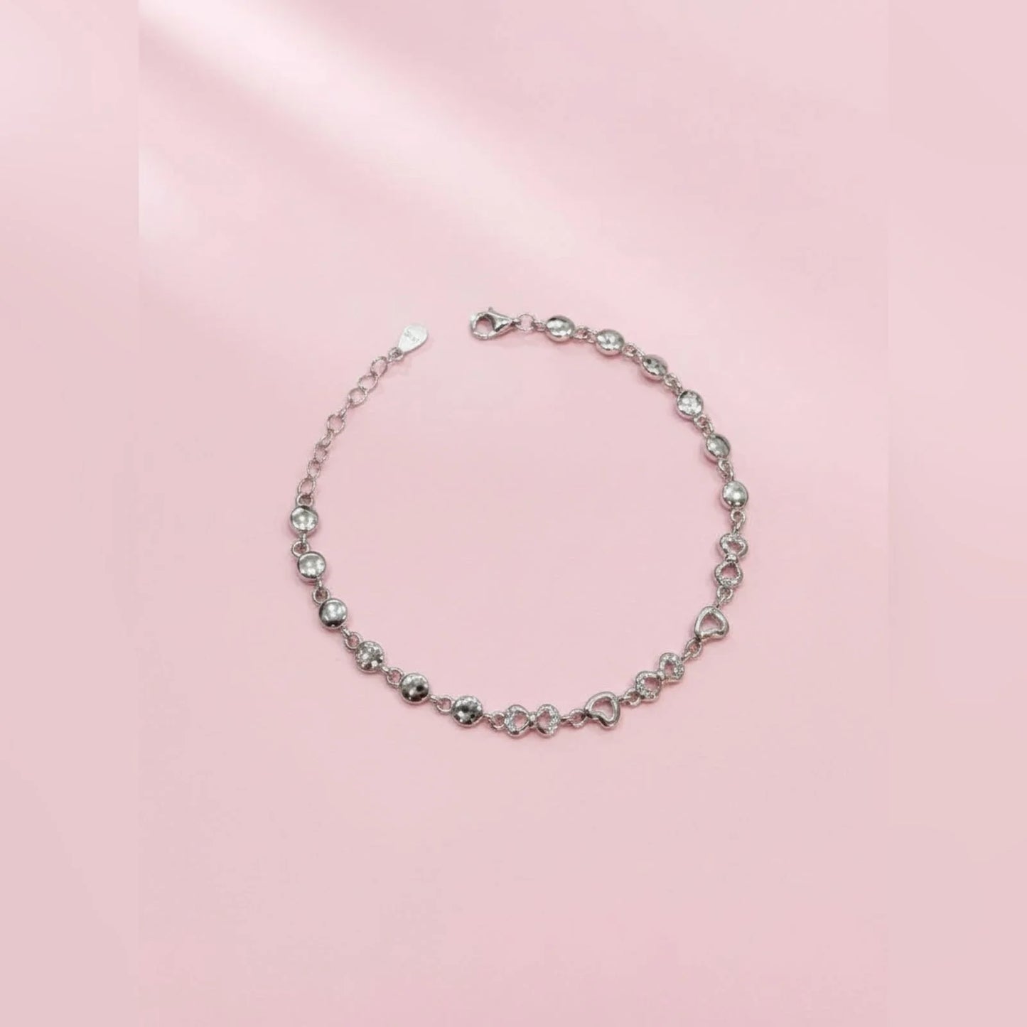 Silver bracelet on a pink background