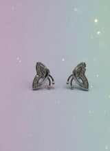 Pair of silver earrings on a gradient background