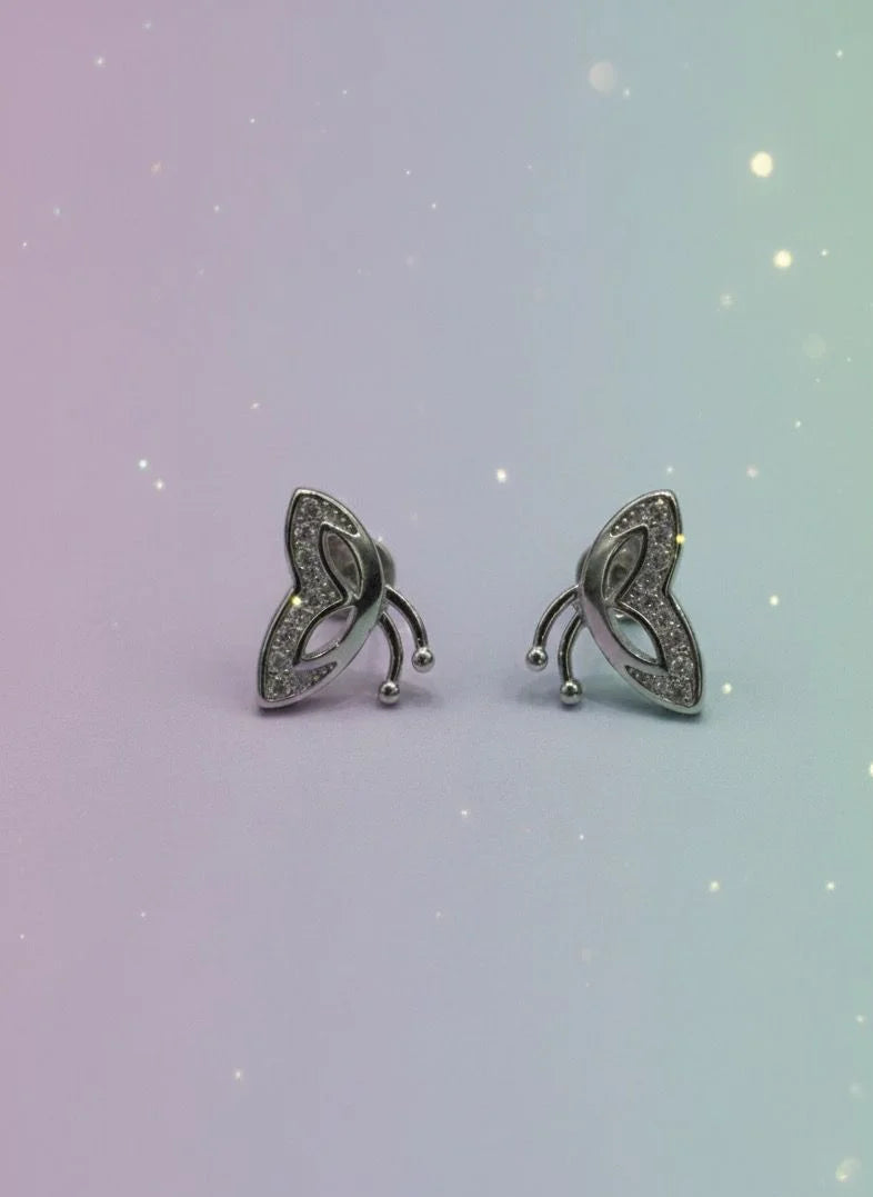 Pair of silver earrings on a gradient background
