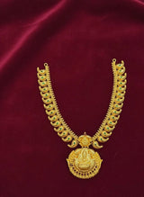Gold necklace with green gemstones on a red fabric background