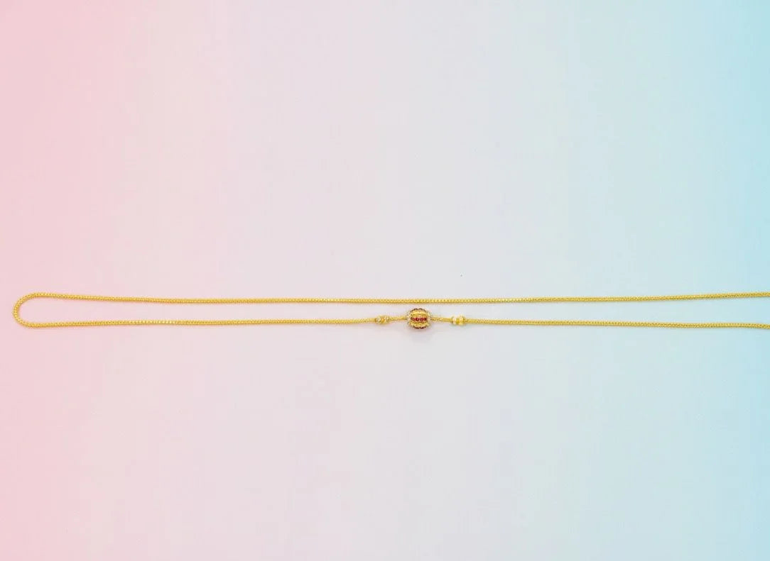 Gold mugappu chain on a gradient pink to blue background