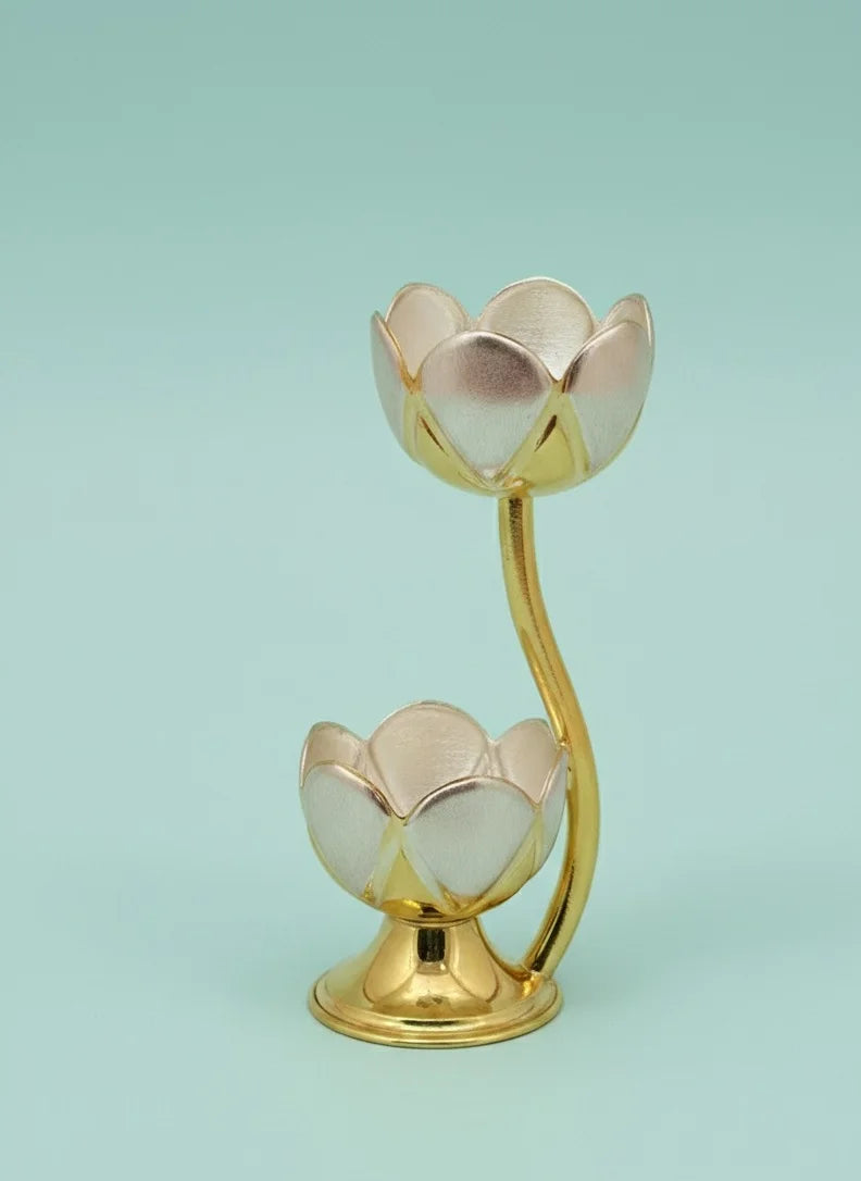 Gold lotus-shaped candle holder on a light blue background