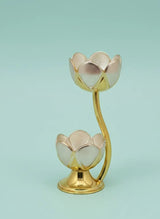 Gold lotus-shaped candle holder on a light blue background