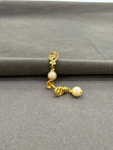 Gold earring with pearls on a gray background