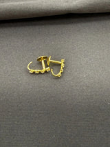 Gold earrings on a gray fabric background