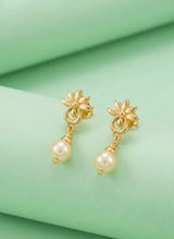 Gold earrings with pearl drops on a green fabric background