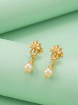 Gold earrings with pearl drops on a green fabric background