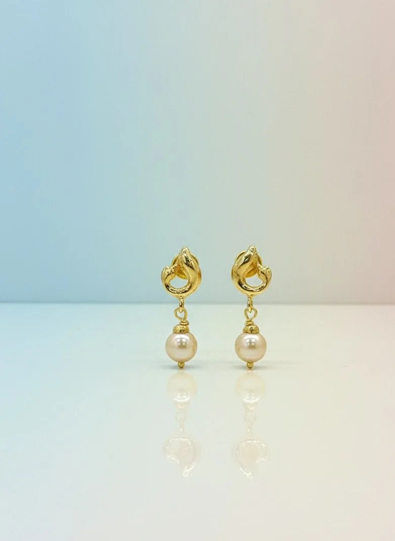 Gold earrings with pearl drops on a gradient background