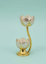 Gold lotus-shaped candle holder on a light blue background