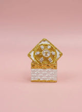 Decorative box with gold and white design on a pink background