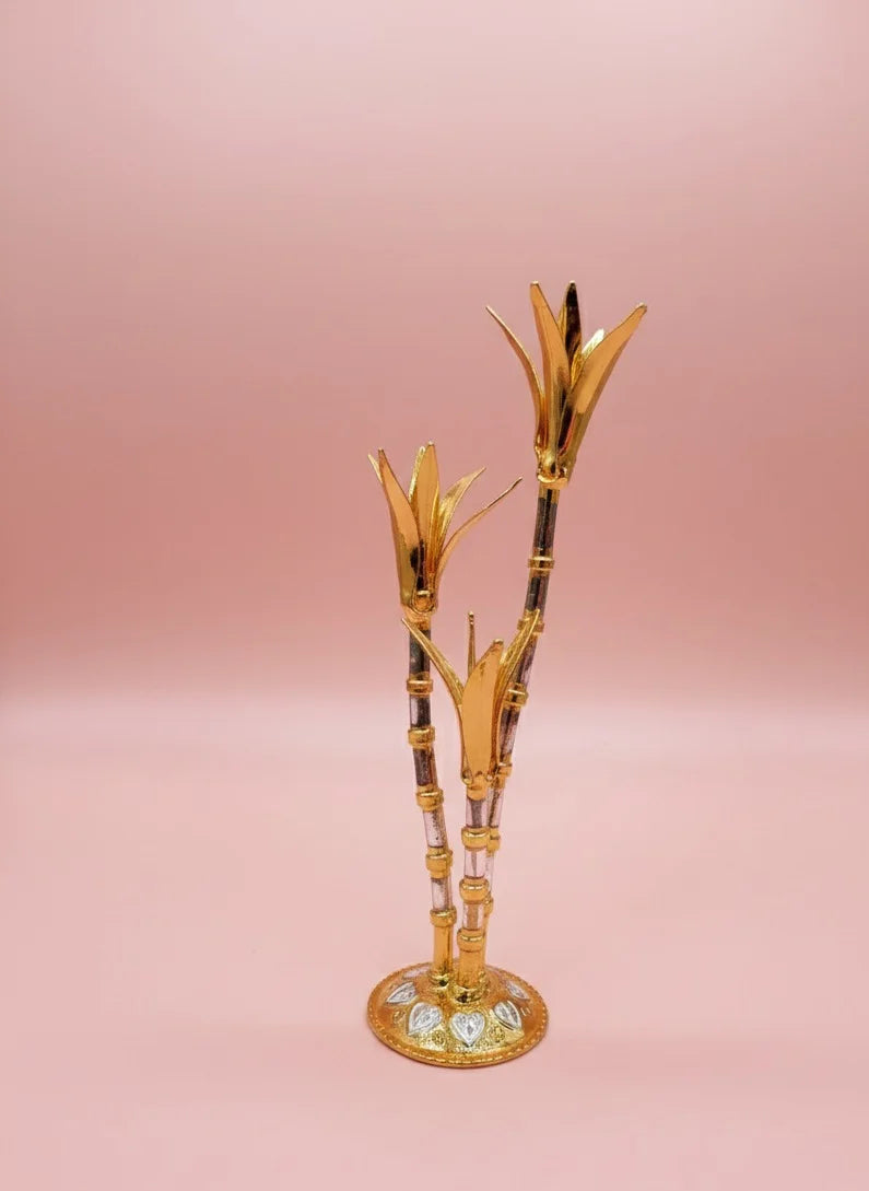 Decorative gold and black bamboo-like object on a pink background