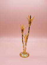 Decorative gold and black bamboo-like object on a pink background