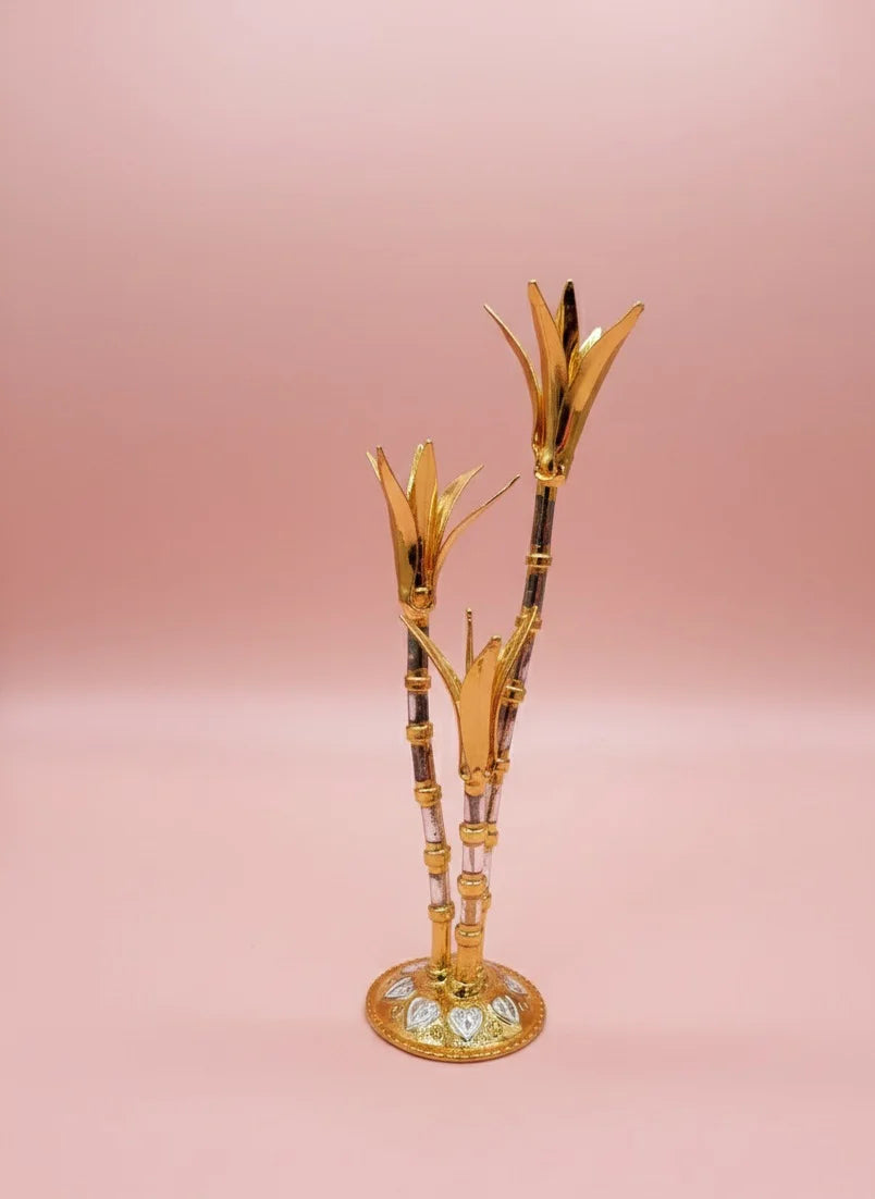 Decorative gold and black bamboo-like object on a pink background