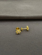 Gold earrings on a gray surface