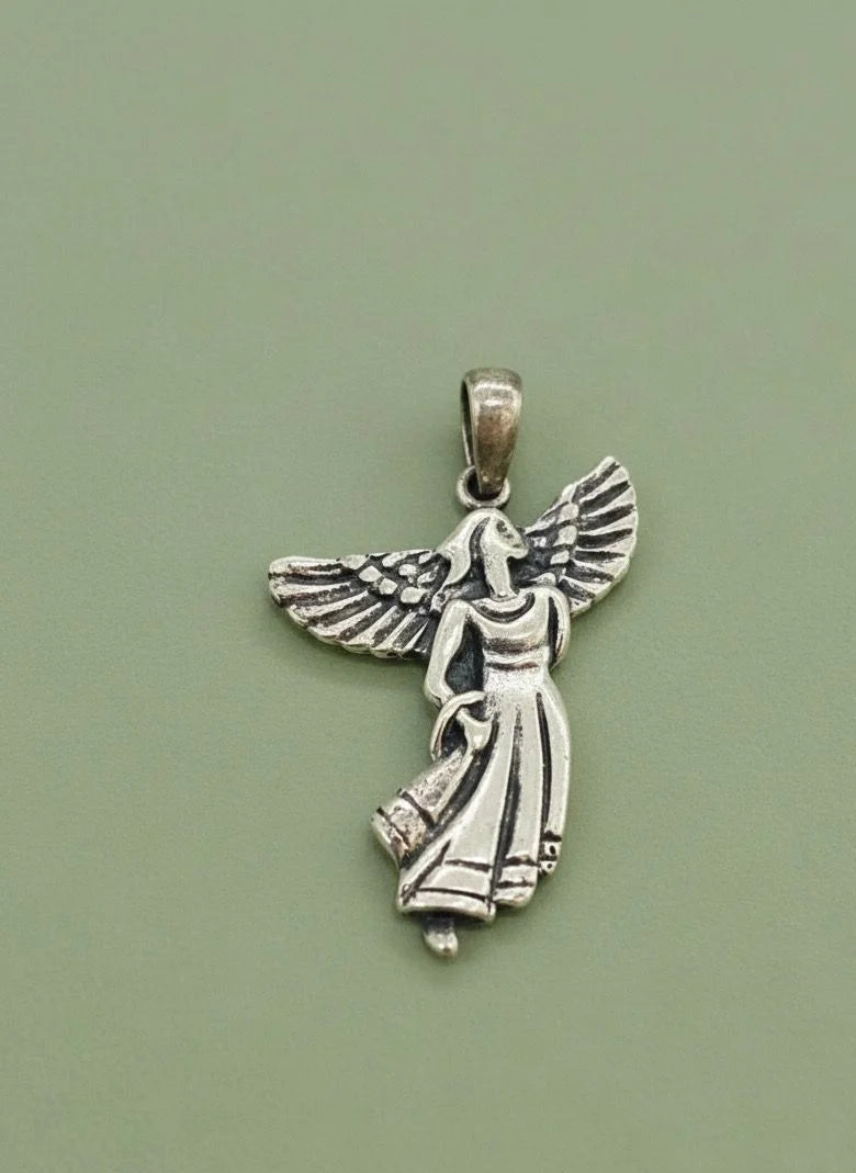 Silver angel pendant on a green background