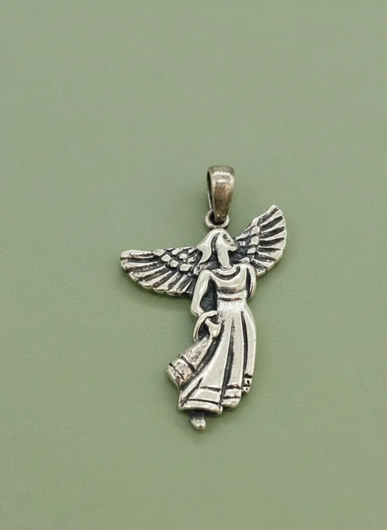 Silver angel pendant on a green background