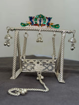 Decorative silver swing with colorful top on a gray background
