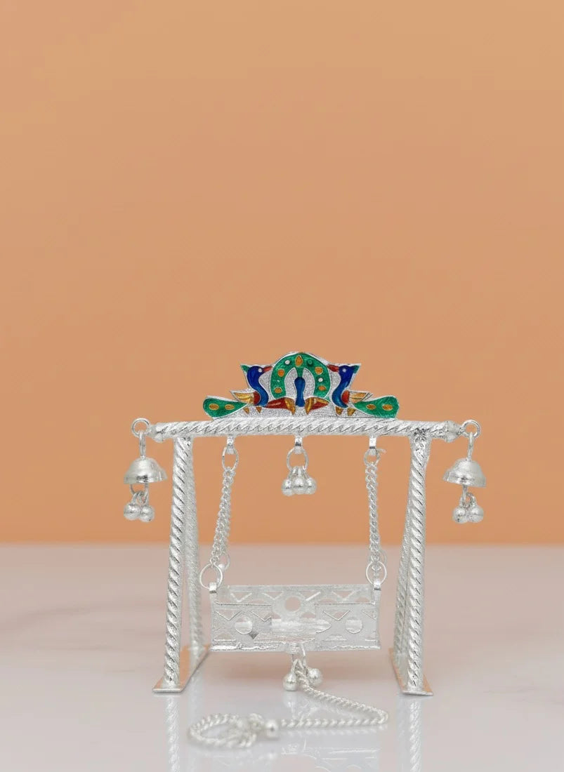 Decorative item with a colorful top and silver base on a peach background