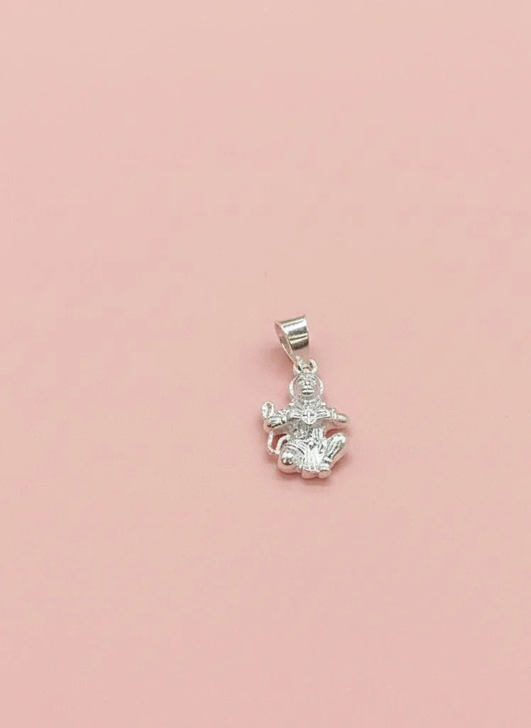 Silver pendant with a clear gemstone on a pink background
