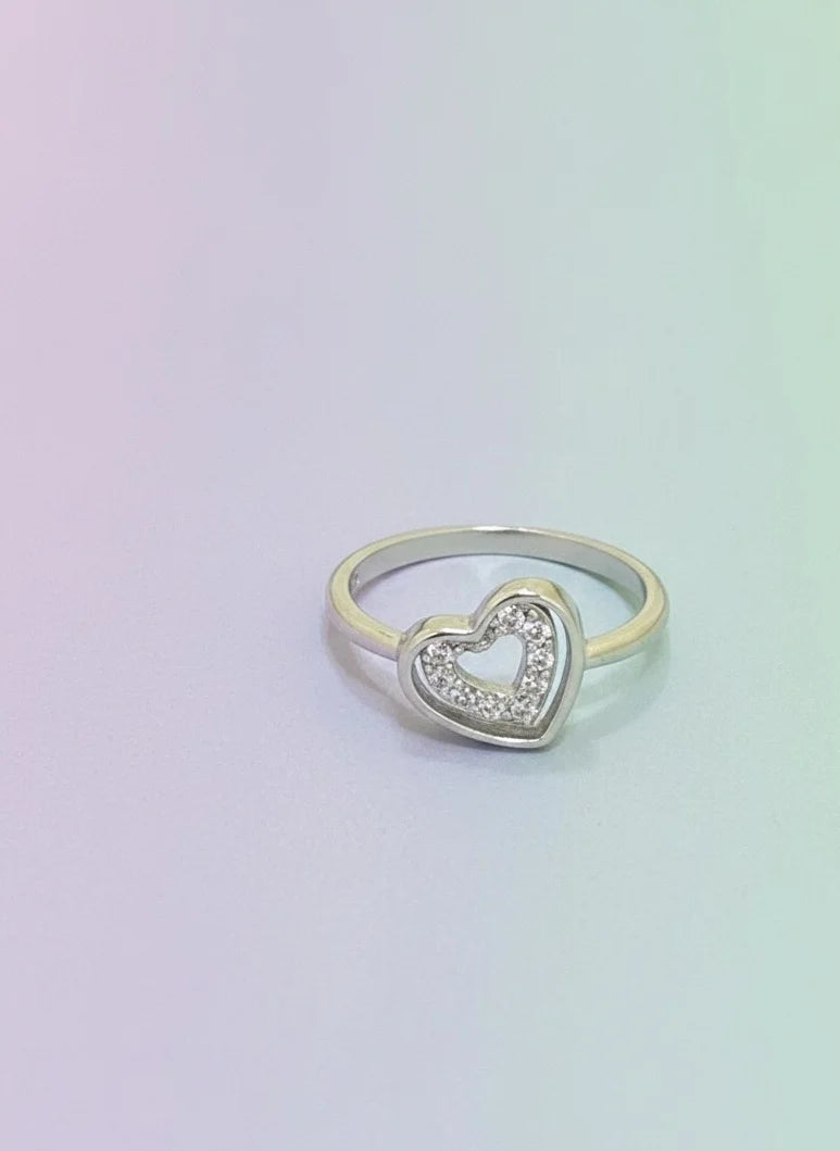 Heart-shaped ring with embedded stones on a gradient background