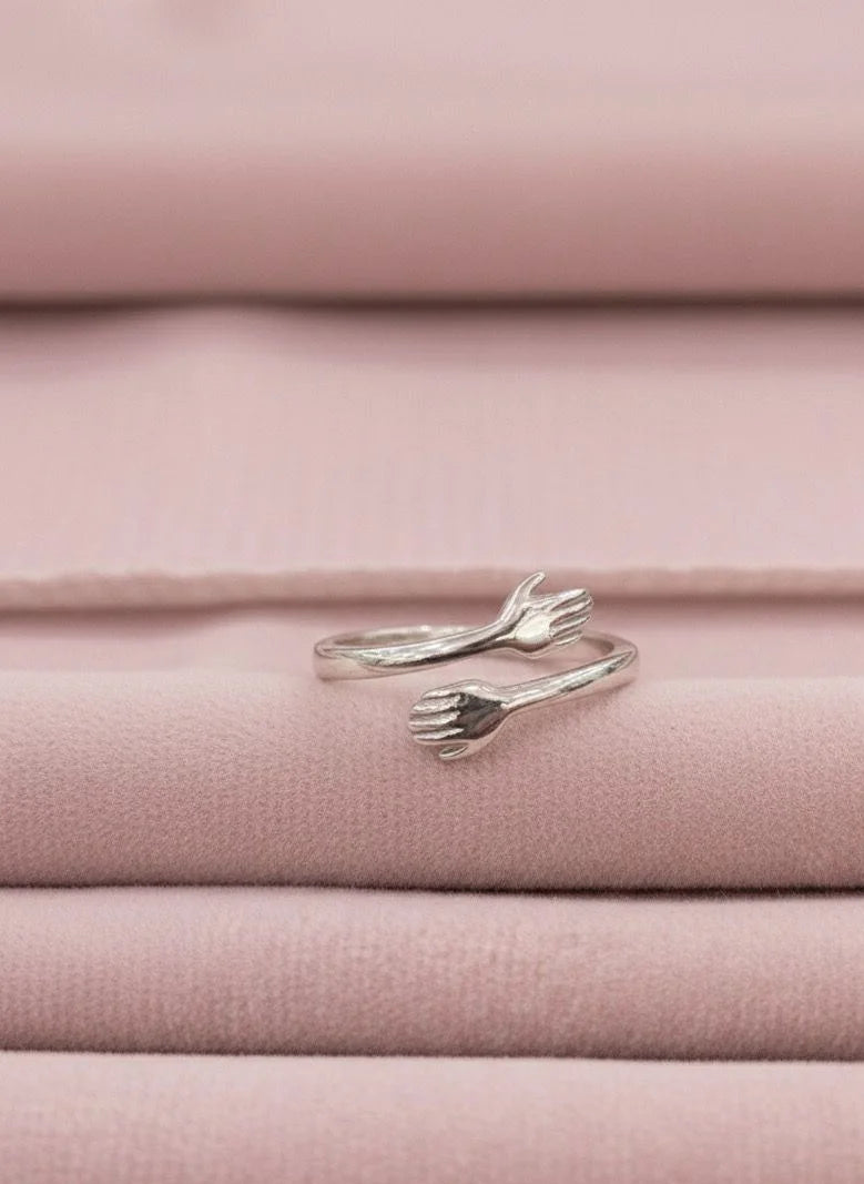 Silver hug ring on pink fabric background