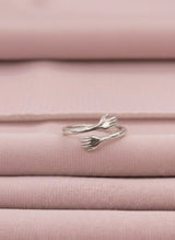 Silver hug ring on pink fabric background