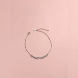 Delicate bracelet with small stones on a pink background