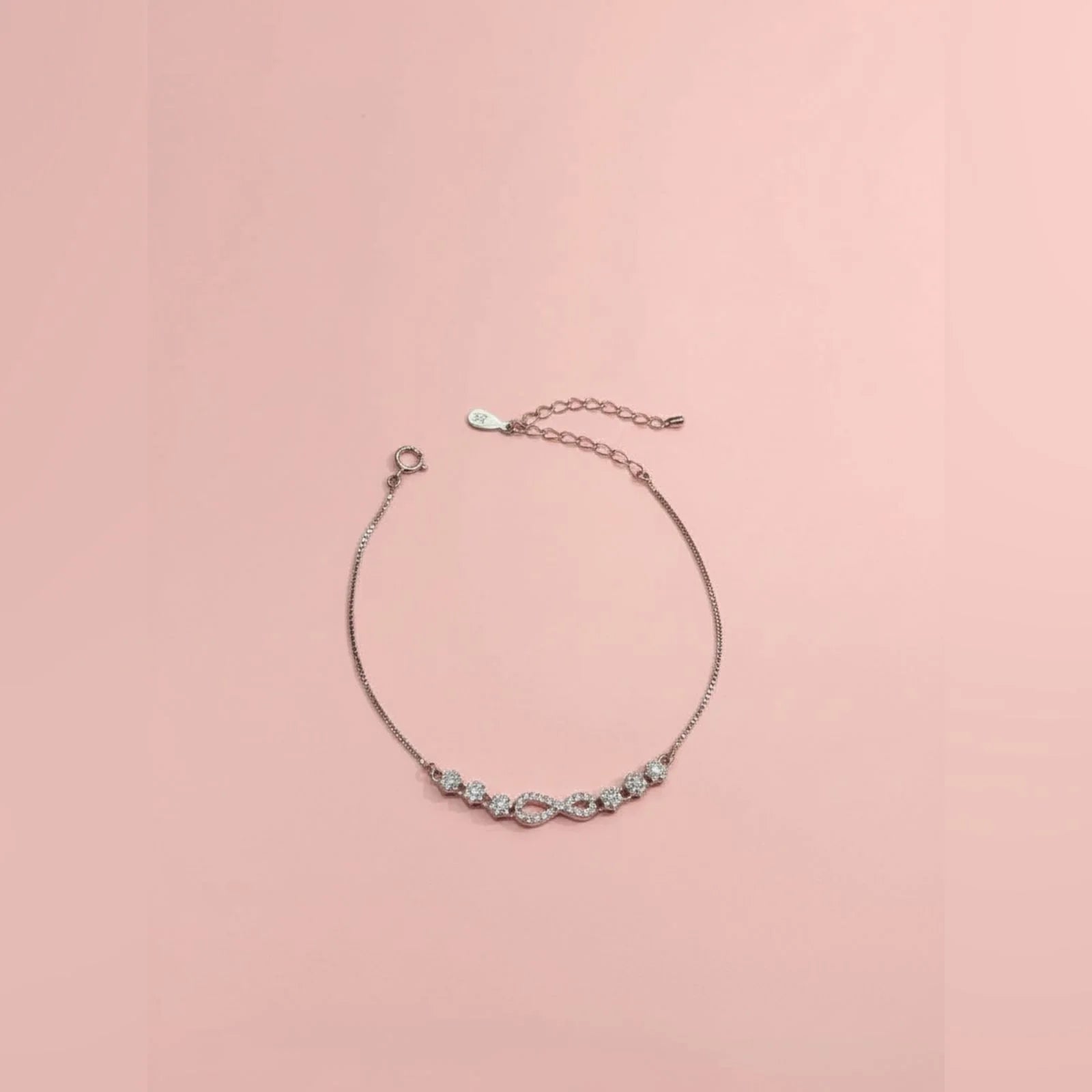 Delicate bracelet with small stones on a pink background