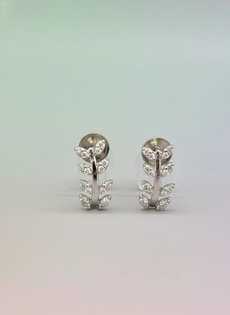 Pair of silver earrings with floral design on a gradient background