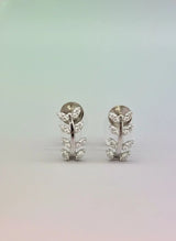 Pair of silver earrings with floral design on a gradient background