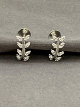 Silver leaf-shaped earrings on a gray background