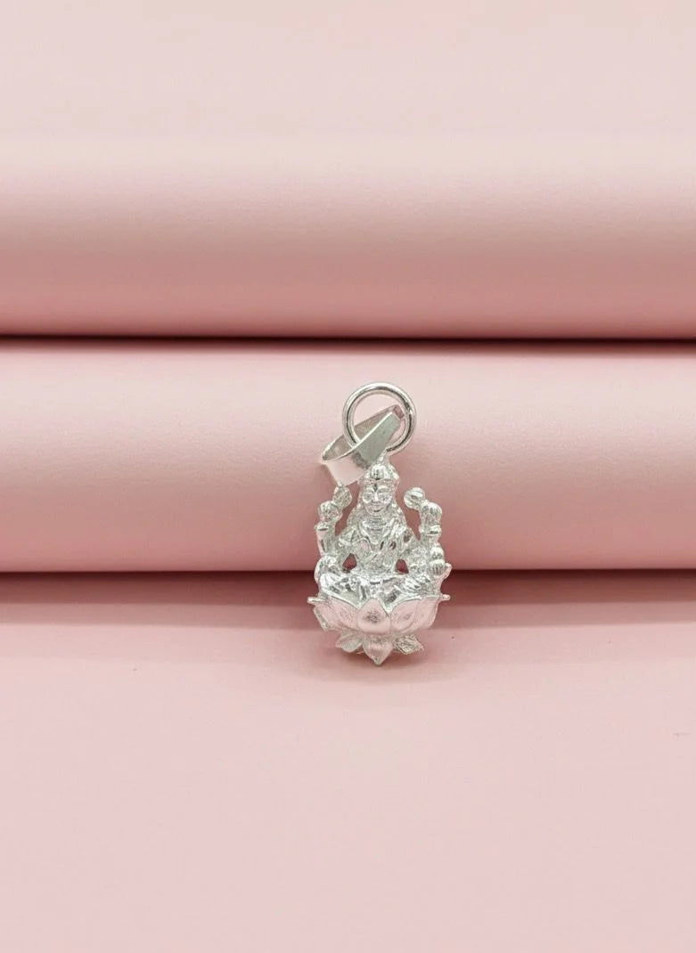 Silver pendant on a pink fabric background