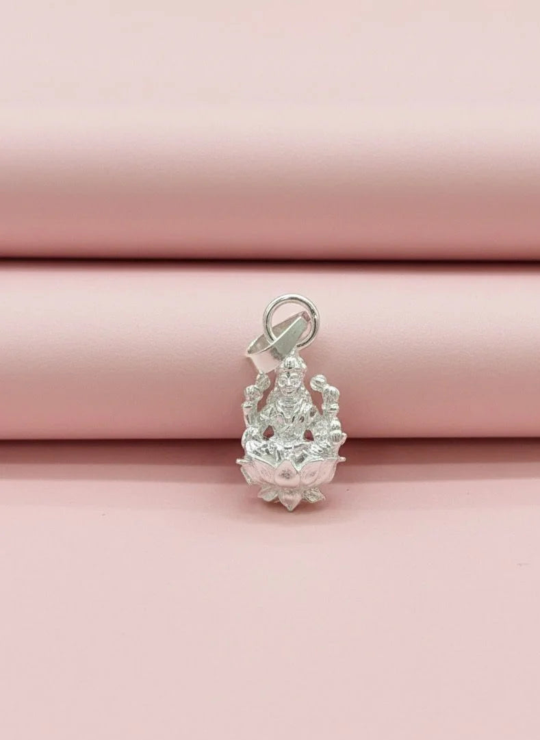 Silver pendant on a pink fabric background