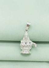 Silver pendant of a deity on a light green fabric background