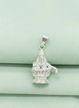 Silver pendant of a deity on a light green fabric background