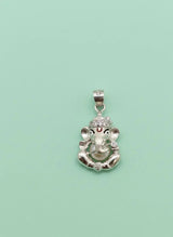 Silver pendant with a deity head design on a light green background