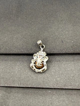 Silver pendant with a face design on a gray surface