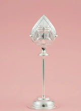 Decorative silver object on a pink background