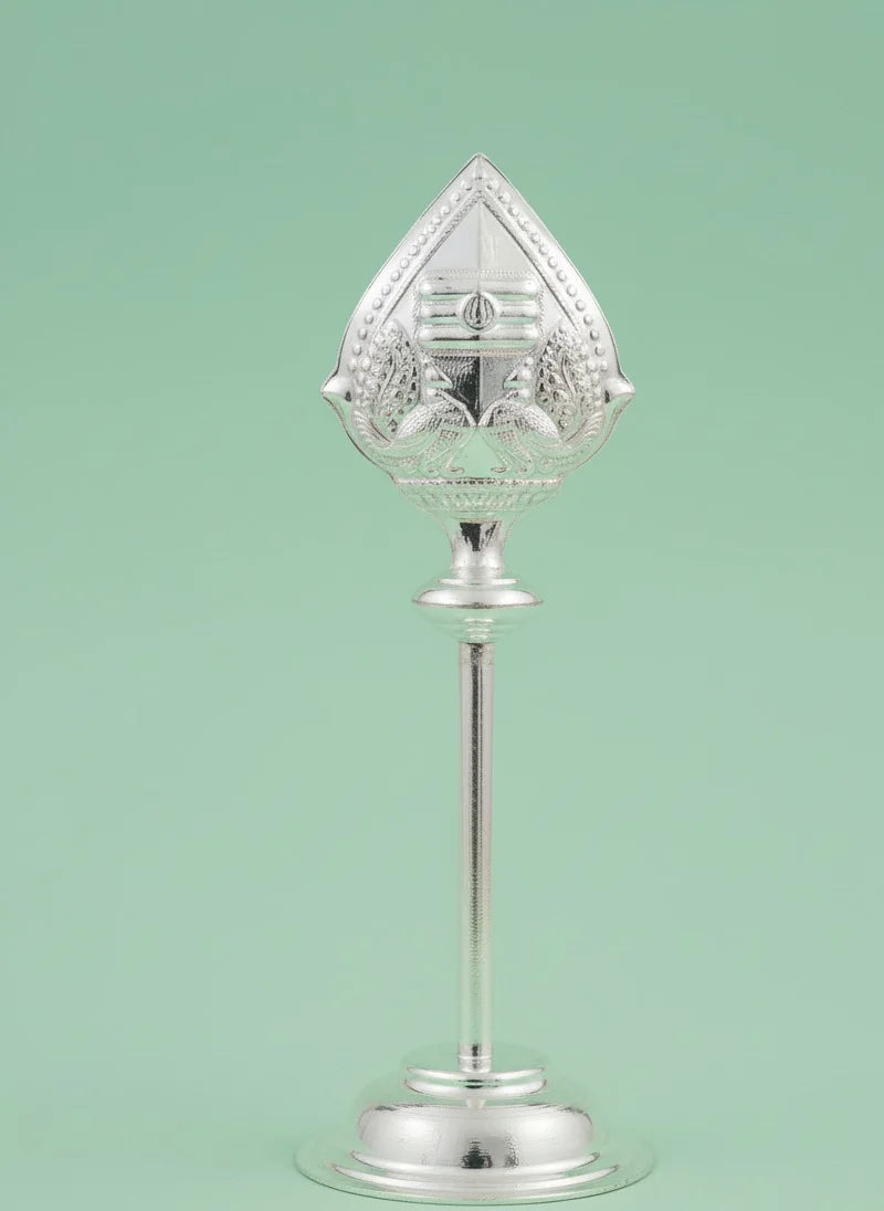 Decorative silver object with a clear glass top on a light green background