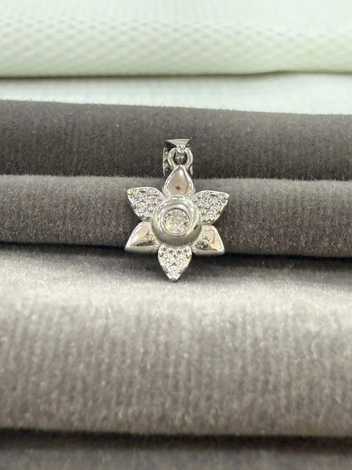 Silver star-shaped pendant on a textured surface