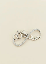 Silver pendant with 'love' engraving on a beige background