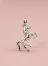 Silver horse pendant on a pink background