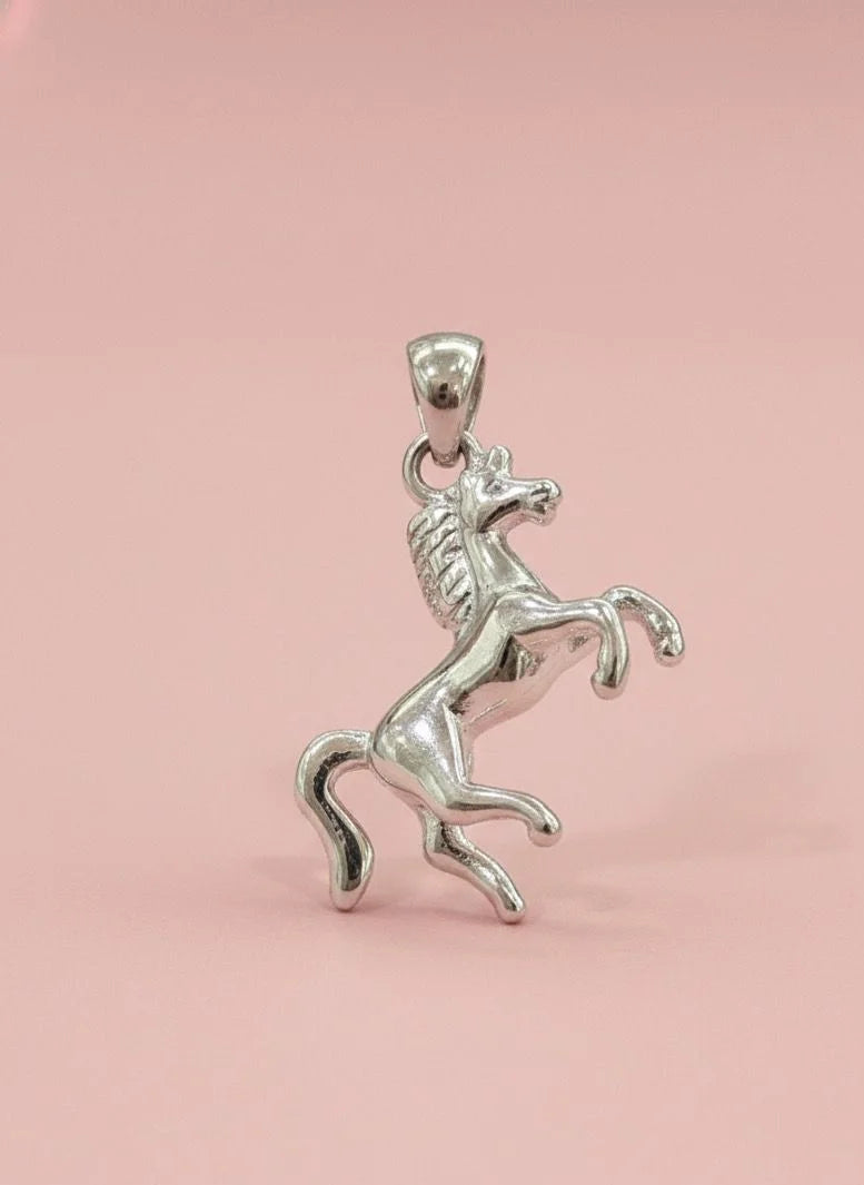 Silver horse pendant on a pink background