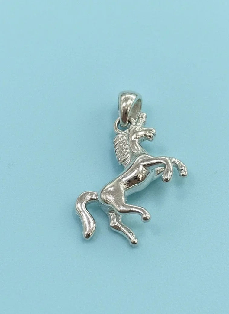 Silver horse pendant on a light blue background