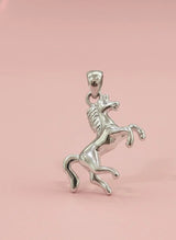 Silver horse pendant on a pink background